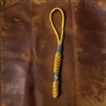 Detail van een gele paracord sleutelhanger met viking runen kralen op vintage leer - Geel