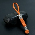 Détail d'un porte-clés en paracorde orange avec tête de mort spartiate et anneau de runes - Orange