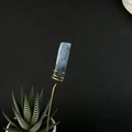 Detailed view of raw blue crystal flower pot stake with handcrafted gold wire wrapping - Black Rutilated Quartz