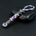 Macro view of handmade paracord keychain with Spartan skull bead and woven rope details - Camo White
