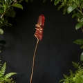 Detailed shot of handmade copper wire-wrapped red crystal hair pin with moss background - Orange Red