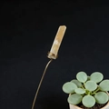 Detail of handmade yellow crystal garden stake with copper wire wrapping on black background - Red Aventurine