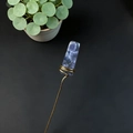 Detail of handcrafted gold wire wrapped blue fluorite crystal pick on black background - Aura Amethyst