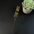 Macro detail of handmade copper wire wrap and long rectangular green crystal hair pin - Tiger's Eye