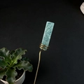 Detail of green crystal stone wrapped in gold wire for decorative plant stakes - Amazonite