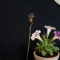 Macro detail of natural stone mushroom plant stake with decorative gold copper wire swirl - Red Sesame Stone