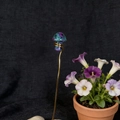 Macro detail of natural crystal mushroom with gold wire wrapping on a slender metal stem - Ruby Zoisite