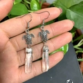 Close-up of bohemian turtle earrings featuring natural white crystal and wire wrap design - White