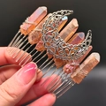 Detailed shot of the crystal hair comb with hollow moon and raw orange quartz stones - Coffee Brown Moon