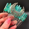 Macro shot of green crystal hair comb with intricate silver crescent moon filigree detail - Green Moon