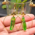 Detailed view of bohemian gold hoop earrings featuring green crystal pendants and wire wrap - Dark Green & Gold Hoop