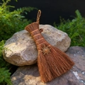 Miniature handmade witch broom with bronze sun pendant on natural mossy rock base - Sun Charm / Bronze
