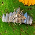 Macro shot of a bohemian crystal hair clip with a silver bee and gray quartz on moss - Gray Crystal With Bee