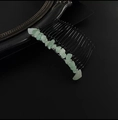 Detailed close-up of 20-tooth black metal hair comb with raw green crystal stones - Green Aventurine