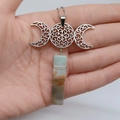 Detailaufnahme der Triple Moon Goddess Halskette mit Naturkristall auf der Hand - Dreifachmond mit Amazonit