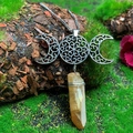 Macro view of handmade triple moon goddess necklace with raw crystal point on mossy bark - Natural / Triple Moon Brown Crystal Necklace
