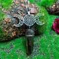 Detailed close-up of triple moon goddess necklace with crystal point on mossy tree bark - Natural / Triple Moon Smoky Crystal Necklace