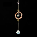 Detail of crystal suncatcher featuring orange gravel ring with sun and moon accents - Red Agate