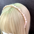 Detail of pink crystal stone headband with handmade gold wire wrapping on a golden wig - Rose Quartz