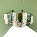 Detail view of handmade bohemian crown with raw stones and a central sun emblem - Moss Agate + White Crystal + Sunflower