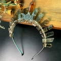 Detail view of handmade crystal moon crown with raw stone pillars on a wood tray - Smoky Quartz + Triple Moon Crown