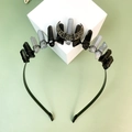 Macro view of gothic crown detailing raw crystals and bronze moon on a black headband - Upright Style