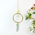 Detailed view of suncatcher featuring a crystal ball and natural fluorite stone pendant - Fluorite