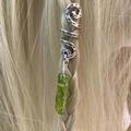 Close-up of a silver spiral hair ring with green crystal stone pendant on braided hair - Emerald Green (11)