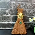 Close-up of mini Wicca broom with golden sun charm and green crystal droplet pendant - Sun God Style (Style 7)