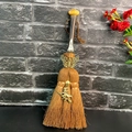Close-up of handmade brown witch broom with crystal moon and metal skull accents - Yellow Translucent Stone Butterfly Witch Style (07)