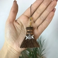 Macro detail of witchy broom pendant featuring pentagram and triple moon symbols - Broom with Triple Moon