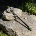 Detailed close-up of fantasy crystal wand with angel wings on a natural rock surface - Green Aventurine Angel Wings