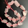 Detailed close-up of natural raw rose quartz beads with organic texture and pink cotton cord - Rose Quartz