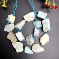 Detailed macro view of raw natural aquamarine stones on a blue braided cord loop - Amazonite