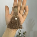 Detailed view of a handmade mini broom keychain featuring natural twigs and a pearl charm - Natural Wood Broom + Pearl / 10cm