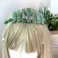 Detalle de corona de cristal verde con alambre de plata, dije de luna y borlas de cadena colgantes - Aventurina Verde