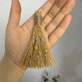 Close-up of handmade mini straw witch broom with amber bead for holiday decor - Amber Bead Style