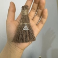Close-up of handmade mini witch broom pendant with silver Celtic Trinity Knot charm - Natural Wood Broom + Celtic Knot / 10cm
