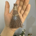 Detailed macro view of a handmade mini wizard broom pendant with a silver sun charm charm - Natural Wood Broom + Sun / 10cm