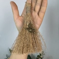 Close-up of handmade mini witch broom with bronze charm and natural straw texture - Broom With Witch