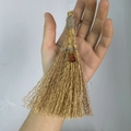 Detail of a handmade mini wicca witch broom with straw texture and gemstone pendant - Broom with Red Agate