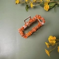 Gros plan de pierres de cristal orange serties dans une pince à cheveux argentée - Pince Argentée + Agate Rouge