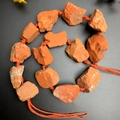 Natural Red Jasper raw stones connected with a woven orange cord in a spiral arrangement - Red Jasper