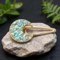 Macro detail of moon-shaped golden hair clip with natural light green crystal stones - Amazonite