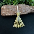 Detailed close-up of handmade witch broom with crystal and sun pendant on bark - 13cm / Flower + Black Crystal
