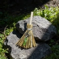 Mini witch broom decor with silver sun pendant and green crystal on a natural rock - 13cm / Flower + Green Crystal
