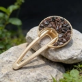 Macro shot of moon hair clip with brown crystal stones on rustic stone surface - Mahogany Obsidian
