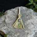 Macro shot of mini witch broom with crescent moon charm and green raw crystal on grey stone - 13cm / Moon + Olive Crackle Crystal