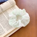 Hellgrünes Blumen-Haargummi mit Karomuster auf einem koreanischen Buchhintergrund - Karo Blumen Patchwork / Grünes Blumenmuster