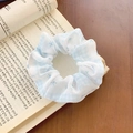 Light blue floral scrunchie with gingham pattern on open book background - Blue Floral